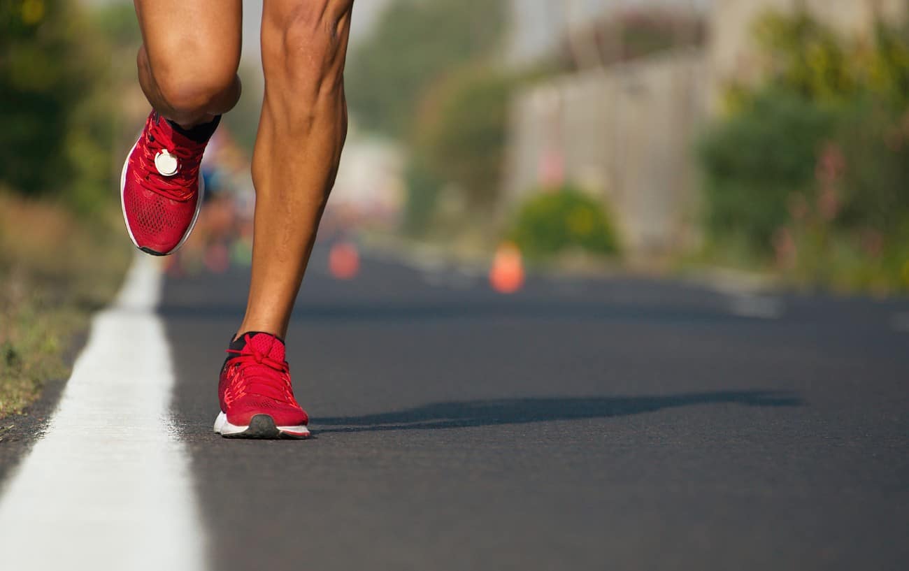 Strong runner feet running on road