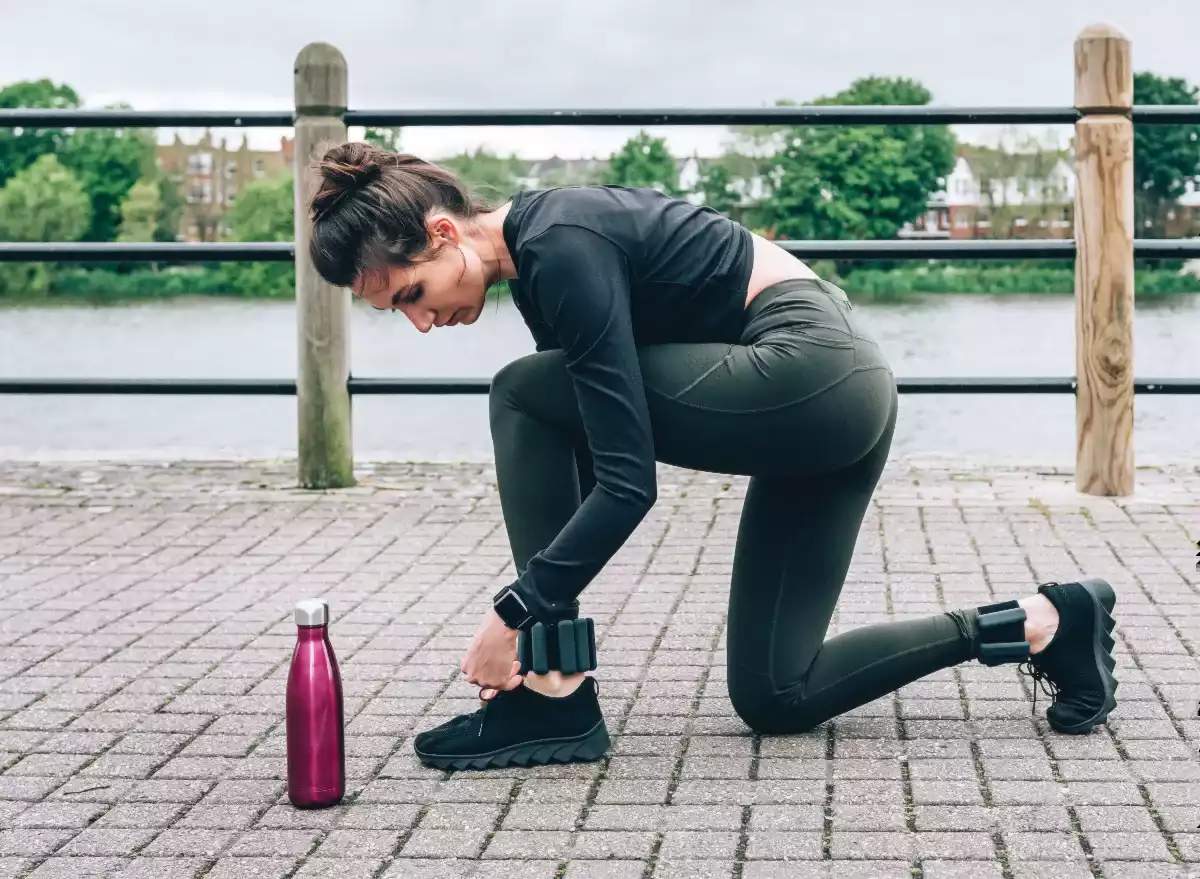 Woman ready for running with leg weights
