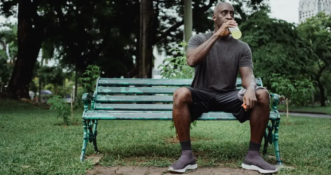 The runner drinks fluid to restore hydration levels