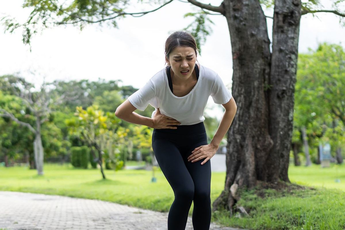 Female runner feel a side cramp while running