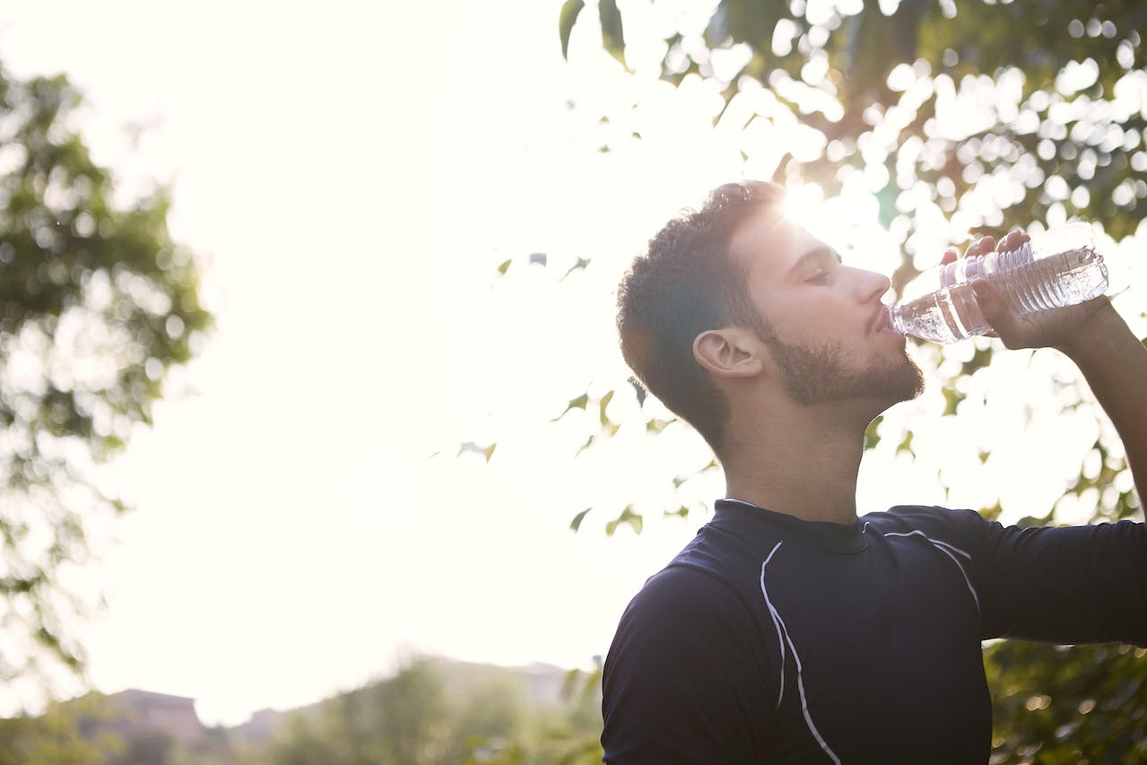 Male runner drink water while running