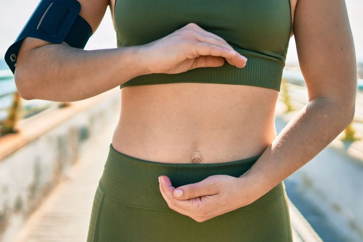 Runner with hands on stomach