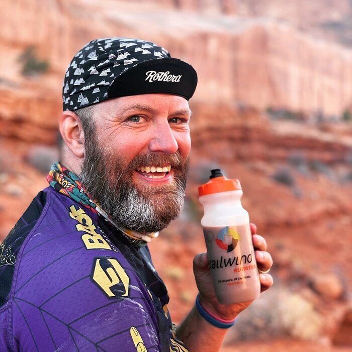 Man holding a bottle of Tailwind Drink Mix