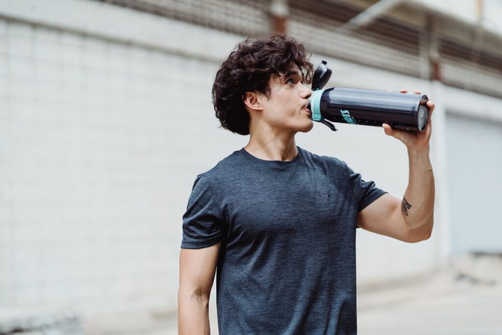 Man drinking sports supplement while running