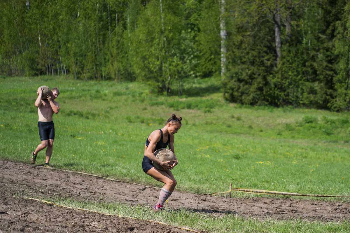 People overcoming obstacles while carrying heavy objects in a Spartan Race