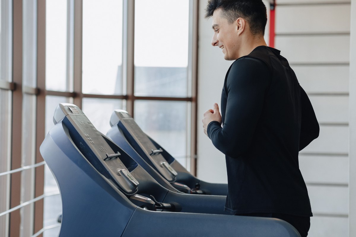 Man running on a home gym treadmill with low ceilings