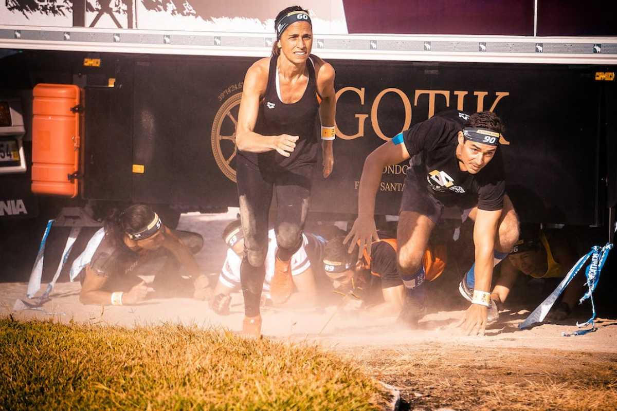 Athletes engaging in a competitive obstacles course race, such as Spartan Race or Tough Mudder