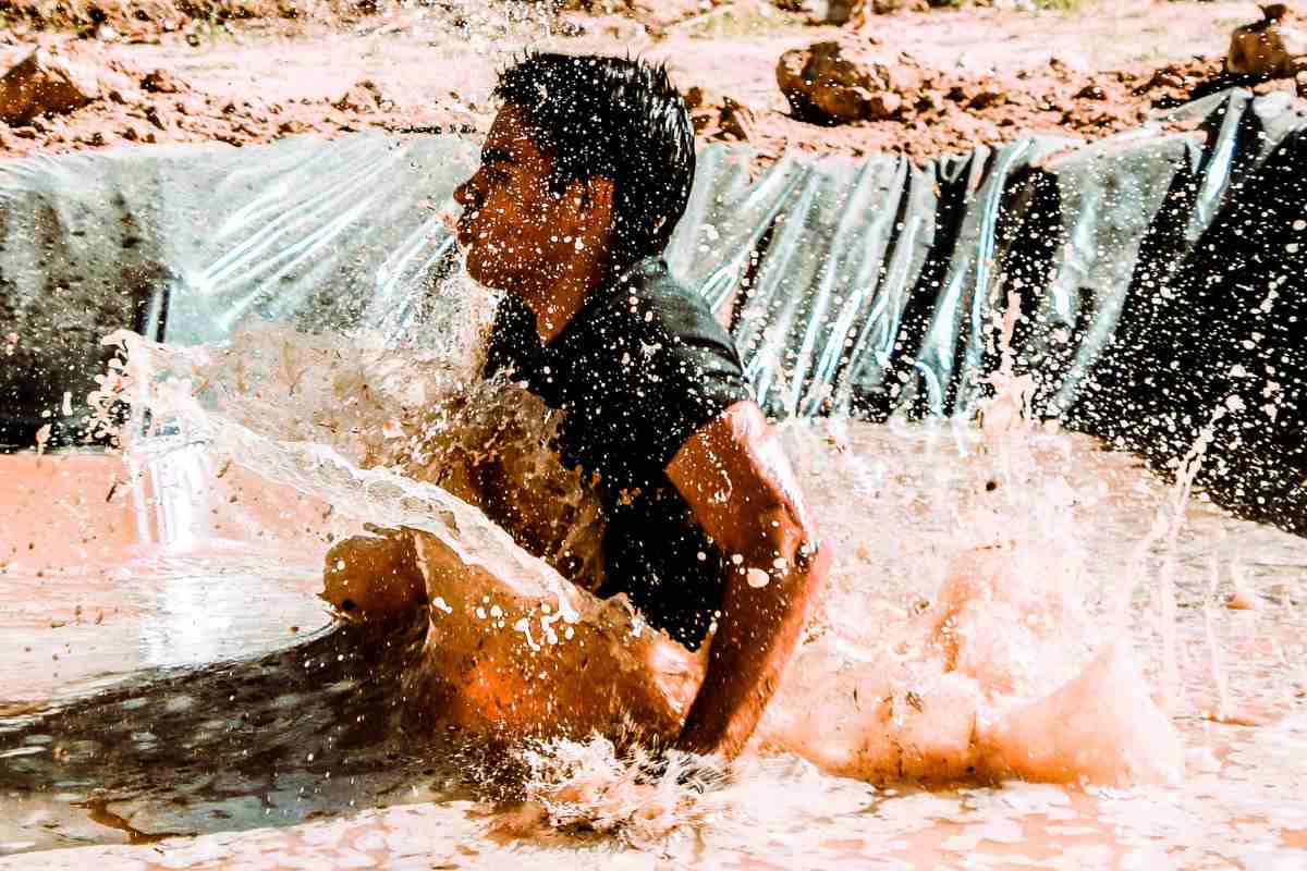 Man overcoming obstacles in a tough mudder race